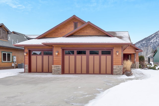 view of front facade featuring a garage, a mountain view, and central AC