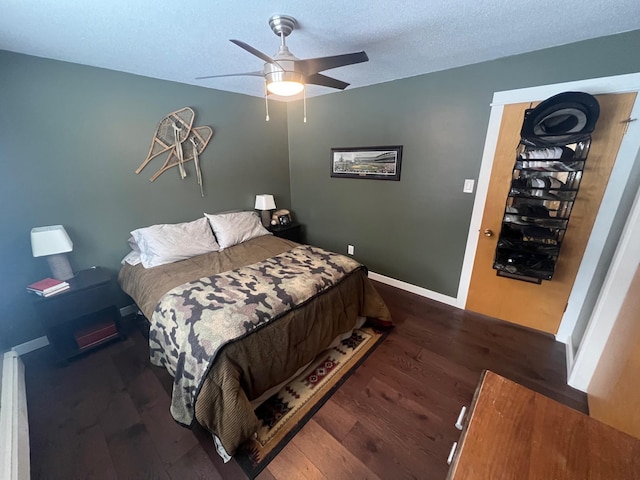 bedroom with ceiling fan, dark hardwood / wood-style floors, and a textured ceiling