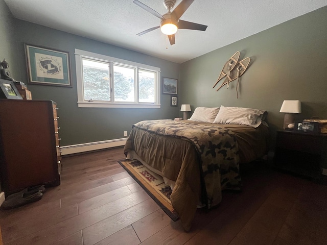 bedroom with a textured ceiling, dark wood-type flooring, ceiling fan, and baseboard heating