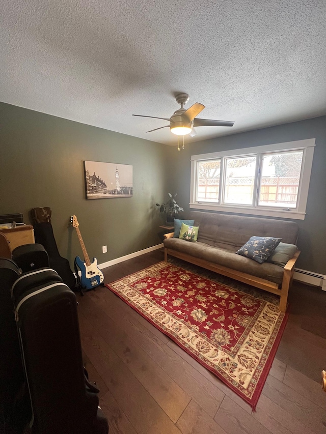 living room with a textured ceiling, wood-type flooring, and ceiling fan