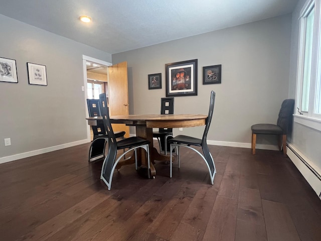 dining space featuring baseboard heating and dark hardwood / wood-style floors