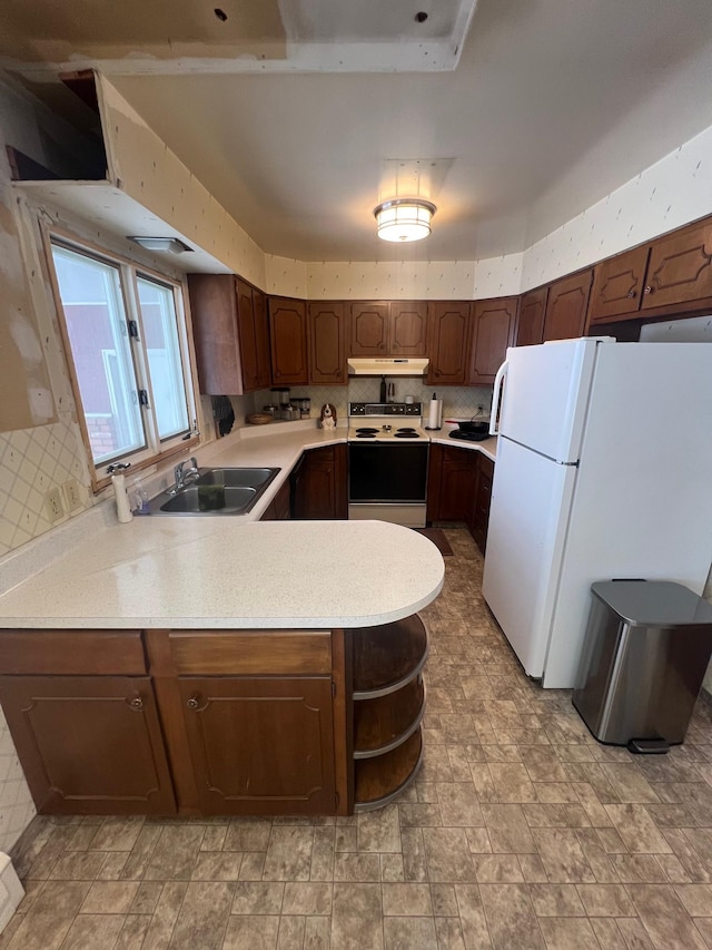 kitchen with sink, decorative backsplash, kitchen peninsula, dark brown cabinets, and white appliances