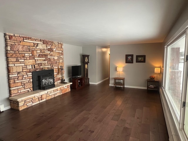 unfurnished living room with dark hardwood / wood-style flooring and a wood stove