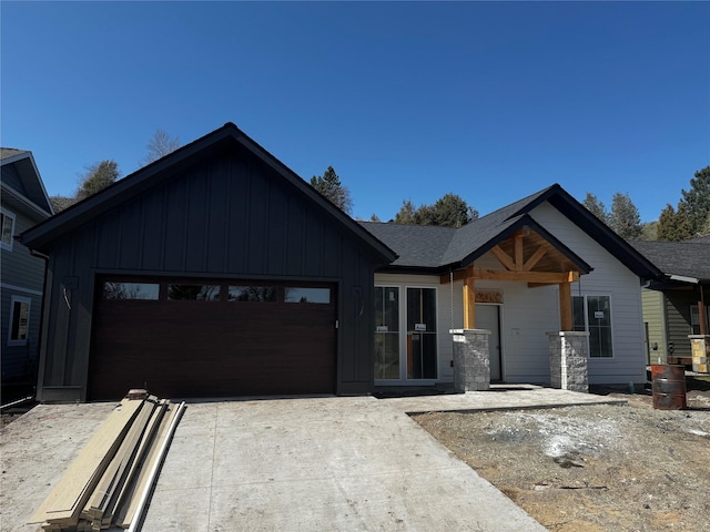 view of front of property with concrete driveway, board and batten siding, and an attached garage