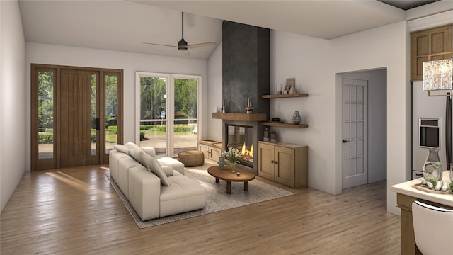 living room featuring ceiling fan, a multi sided fireplace, lofted ceiling, and light wood-type flooring