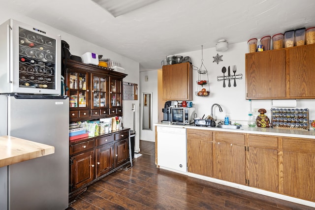 kitchen with sink, dark wood-type flooring, and white dishwasher