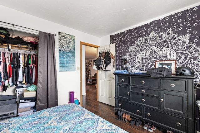 bedroom with dark hardwood / wood-style floors and a closet