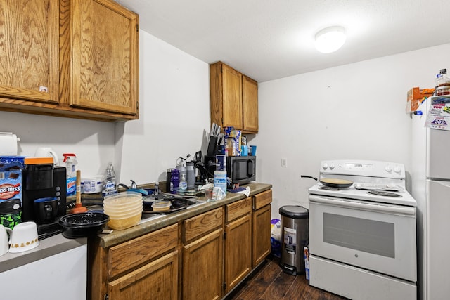 kitchen featuring dark hardwood / wood-style floors and white appliances