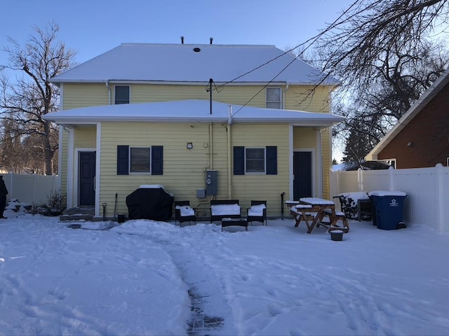 snow covered property with fence