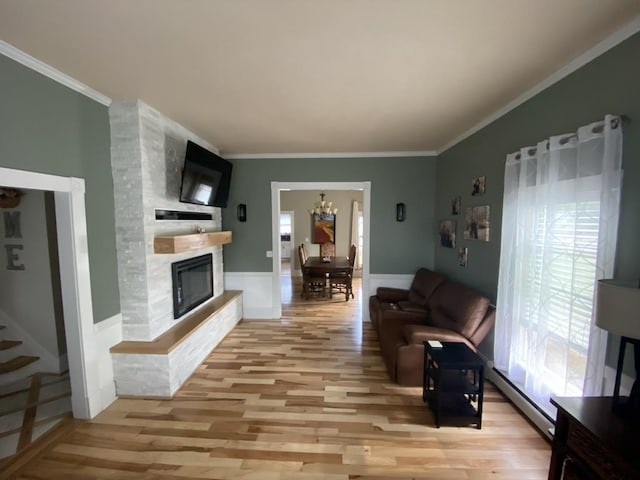 living area with stairs, ornamental molding, a fireplace, and light wood-style floors