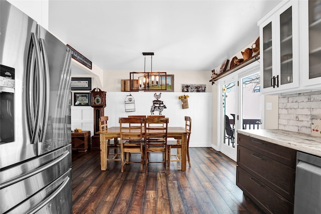 dining room featuring dark hardwood / wood-style floors and an inviting chandelier