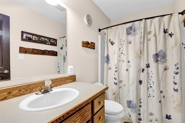 bathroom with vanity, toilet, and curtained shower