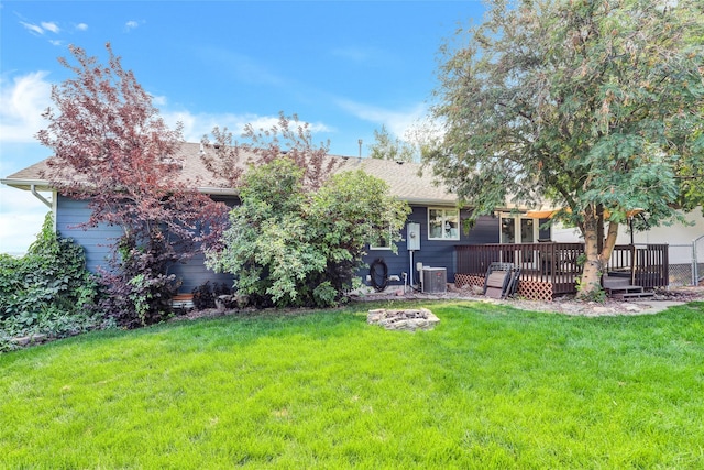 view of yard featuring an outdoor fire pit, a deck, and central air condition unit