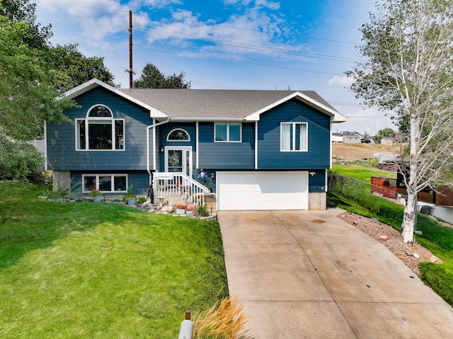 bi-level home featuring a garage and a front lawn