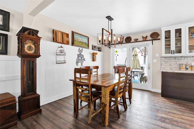 dining room with dark hardwood / wood-style floors and a notable chandelier