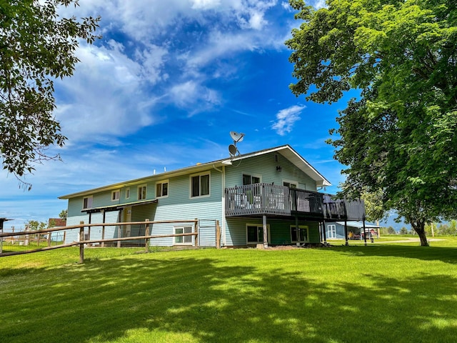 rear view of property featuring a deck and a lawn