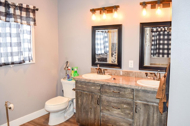 bathroom with wood-type flooring, toilet, and vanity