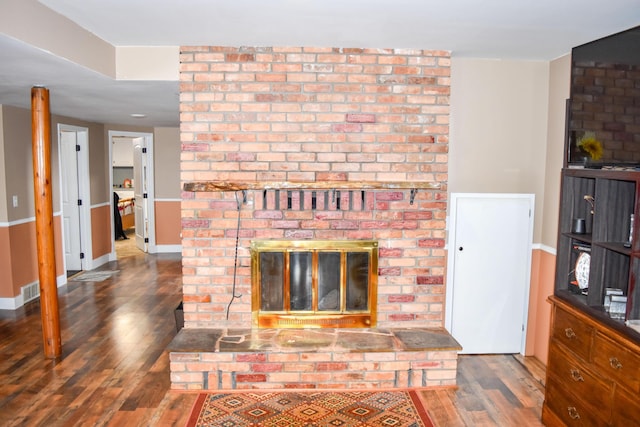 living room featuring dark hardwood / wood-style flooring and a brick fireplace