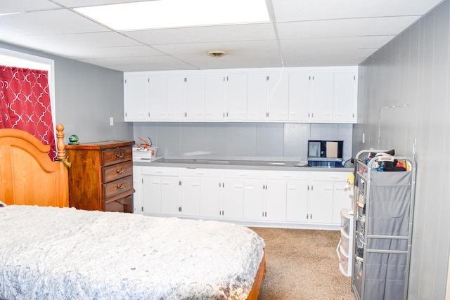 bedroom featuring a paneled ceiling and light carpet