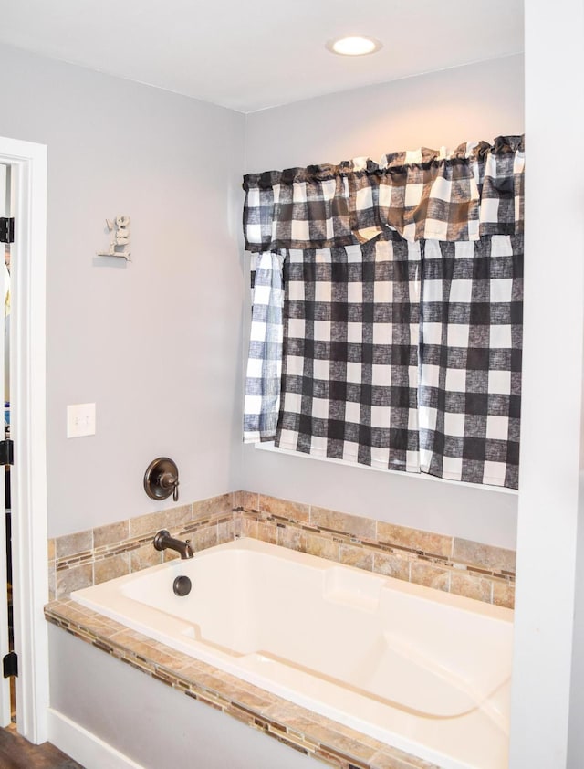 bathroom featuring tiled tub