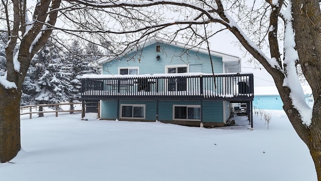 snow covered rear of property featuring a deck