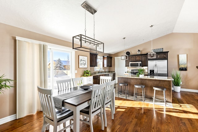 dining space with lofted ceiling, dark hardwood / wood-style floors, and sink