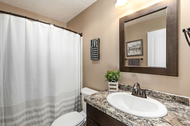 bathroom with vanity, a textured ceiling, and toilet