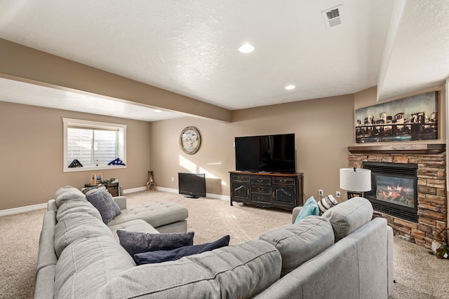 living room featuring a stone fireplace, a textured ceiling, and carpet flooring