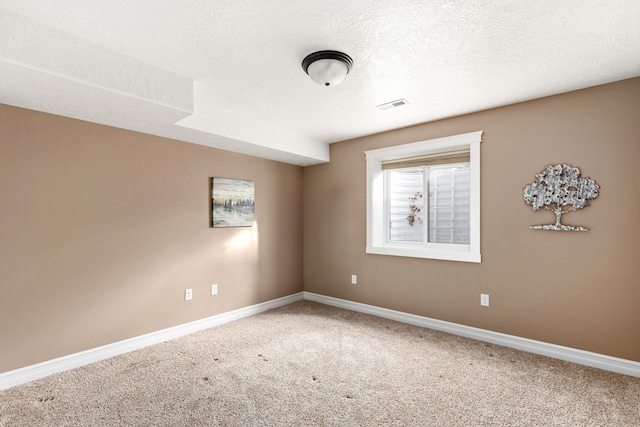 carpeted spare room with a textured ceiling