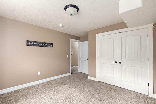 unfurnished bedroom with a closet, a textured ceiling, and carpet