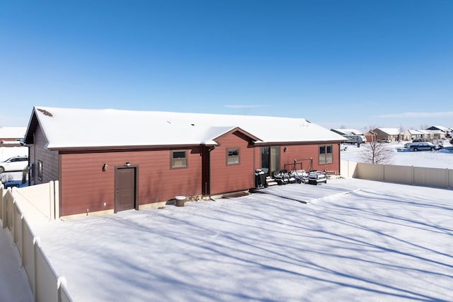 view of snow covered back of property