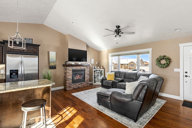 living room featuring ceiling fan, a fireplace, lofted ceiling, and dark hardwood / wood-style flooring