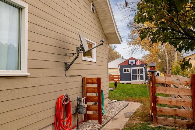 view of side of home featuring a storage unit and a lawn