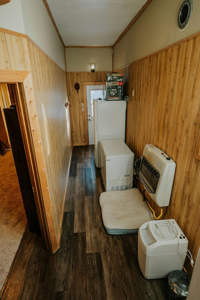 interior space featuring dark wood-type flooring, wooden walls, and ornamental molding