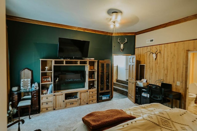 interior space featuring crown molding, ceiling fan, carpet flooring, and wooden walls