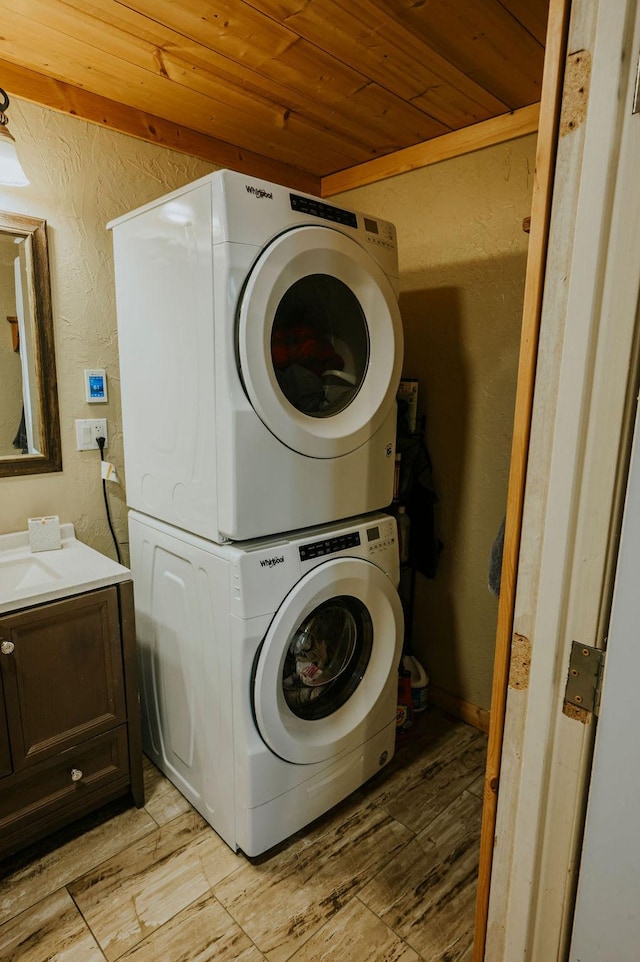 washroom featuring stacked washing maching and dryer, wood ceiling, and light hardwood / wood-style floors