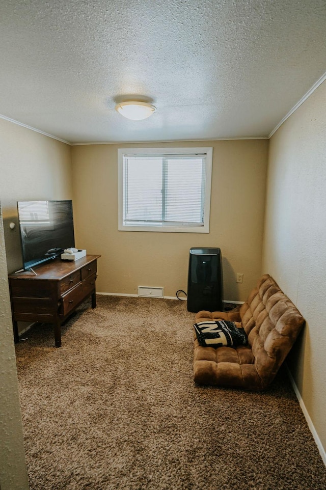 living area with ornamental molding, carpet floors, and a textured ceiling