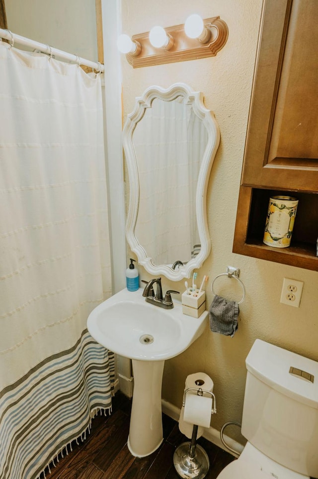 bathroom featuring hardwood / wood-style floors and toilet