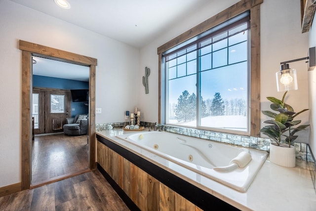 bathroom featuring hardwood / wood-style floors and tiled tub