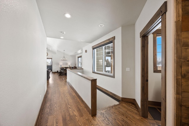 hallway with dark hardwood / wood-style flooring and vaulted ceiling