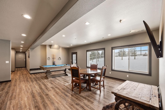 dining room with hardwood / wood-style flooring, pool table, and a textured ceiling