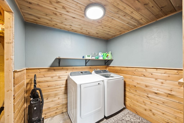 washroom featuring wooden walls, wooden ceiling, and washing machine and clothes dryer