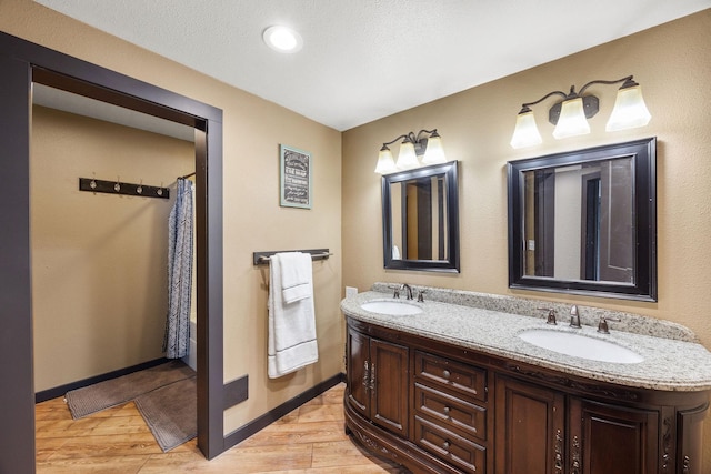 bathroom featuring wood-type flooring, vanity, and a textured ceiling