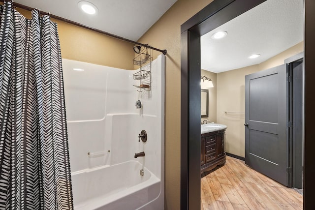 bathroom featuring vanity, hardwood / wood-style floors, and washtub / shower combination