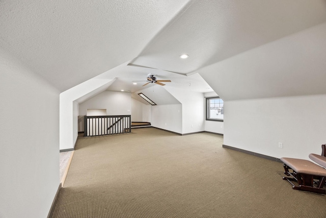 bonus room with lofted ceiling, light colored carpet, and a textured ceiling