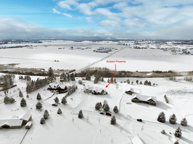 snowy aerial view featuring a rural view