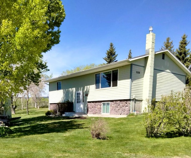 rear view of property featuring a yard