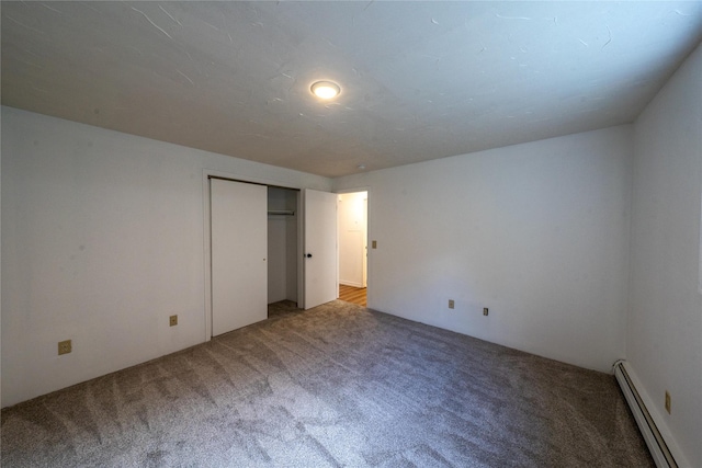 unfurnished bedroom with a baseboard radiator, a closet, and carpet