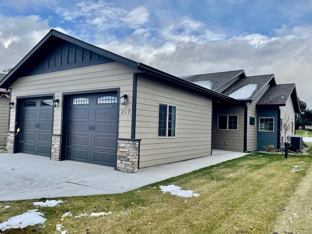 exterior space featuring a garage, a front yard, and central air condition unit