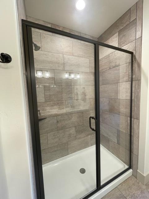 bathroom with tile patterned flooring and a shower with door